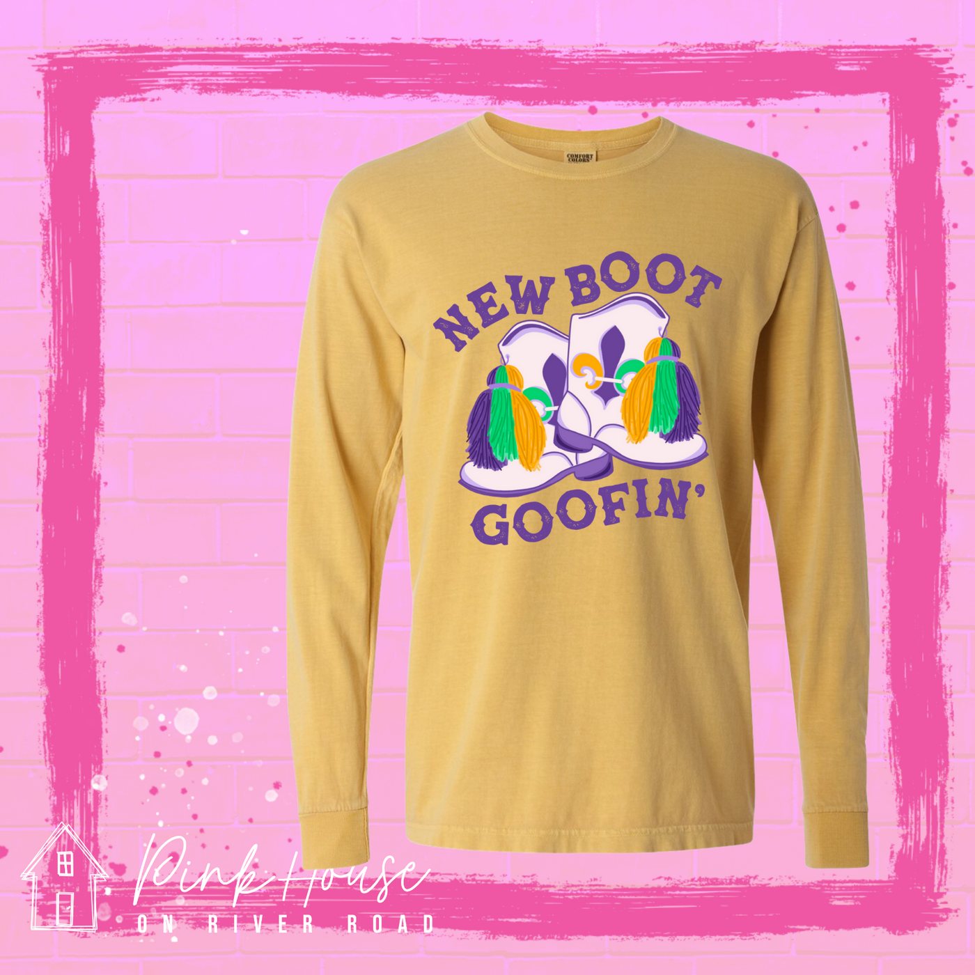 A Mustard long sleeve tee with a graphic. Graphic is of a pair of majorette boots, the boots have a tassel and fleur de lis both in gold, green and purple. the words New Boot are above the boots and the word goofin' is below thee boots the words are in purple.