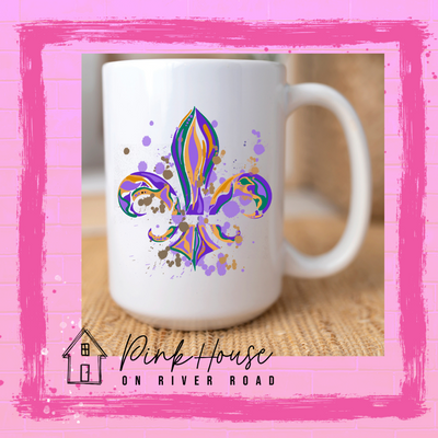 White coffee mug with a Fleur de Lis made up of layered green, yellow, and purple with green, yellow and purple colored splatters.
