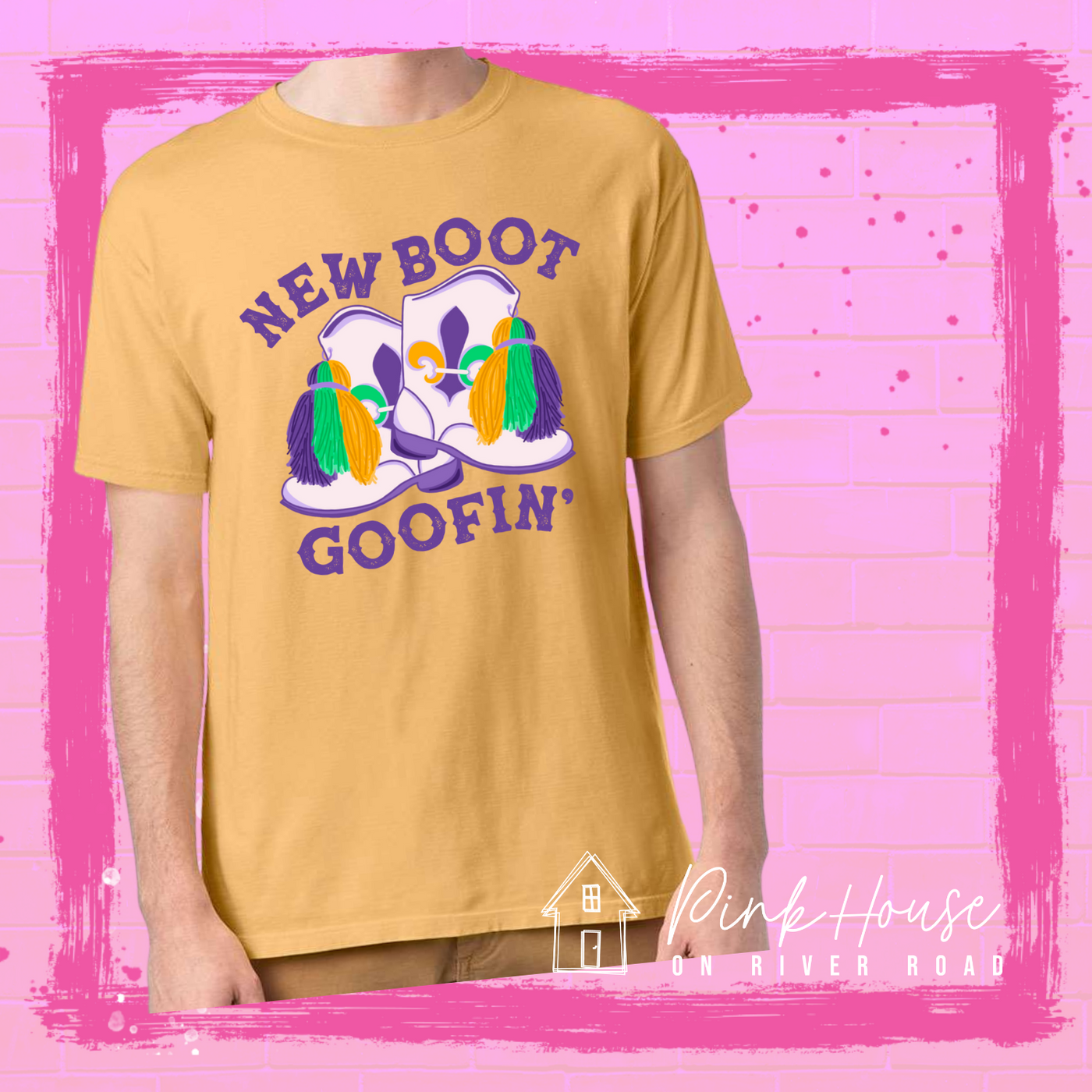 A Mustard tee with a graphic. Graphic is of a pair of majorette boots, the boots have a tassel and fleur de lis both in gold, green and purple. the words New Boot are above the boots and the word goofin' is below thee boots the words are in purple.