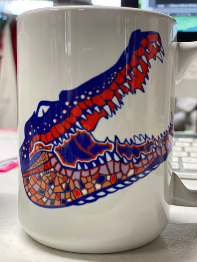 White Coffee mug with a blue, orange, and white layered gator