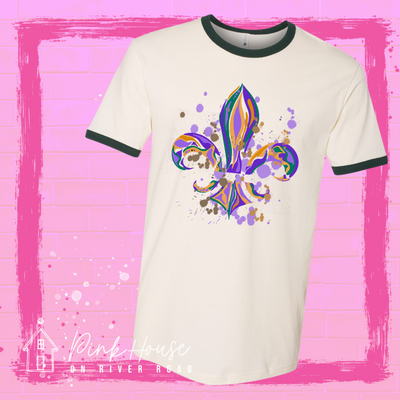 White and green ringer tee with a Fleur de Lis made up of layered green, yellow, and purple with green, yellow and purple colored splatters.