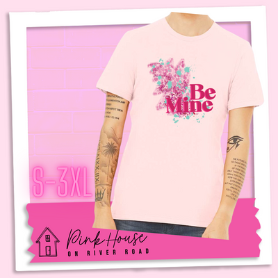 Soft Pink Jersey Tee with a squiggle design made of pink hearts and pink sparkles with light teal splatters and pink text at the end of the art that says Be Mine with a hot pink shadow.
