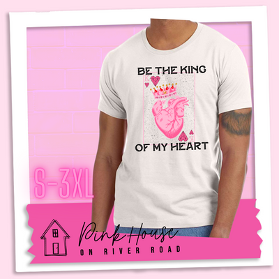 Dust Tee with a graphic that says "Be The King Of My Heart" in Black writing with a vintage effect. There is a King PLaying card with a speckled background, geometric hearts in the corners with the K and a realistic heart with a crown on it in the middle of the playing card.