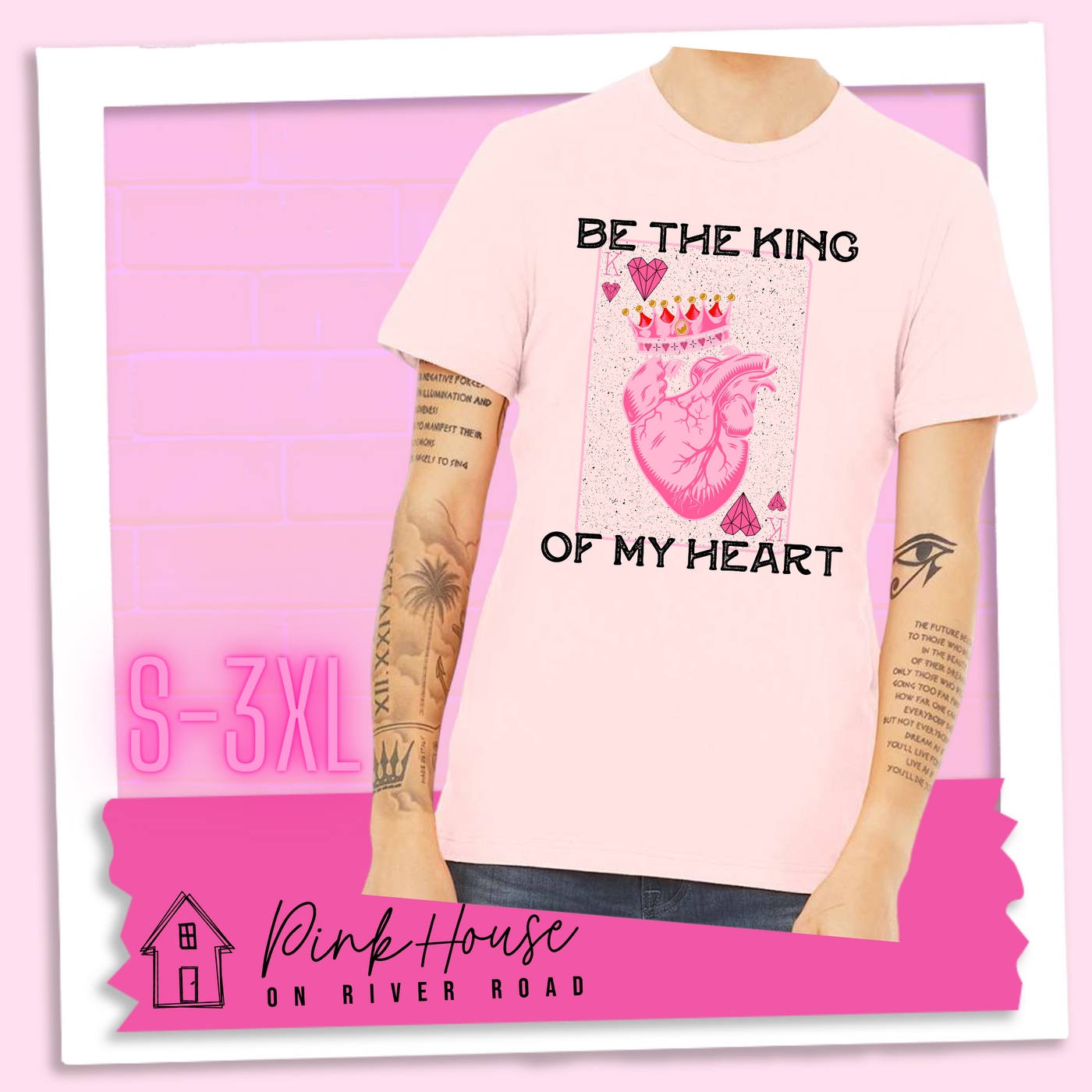 Soft Pink Jersey Tee with a graphic that says "Be The King Of My Heart" in Black writing with a vintage effect. There is a King PLaying card with a speckled background, geometric hearts in the corners with the K and a realistic heart with a crown on it in the middle of the playing card.