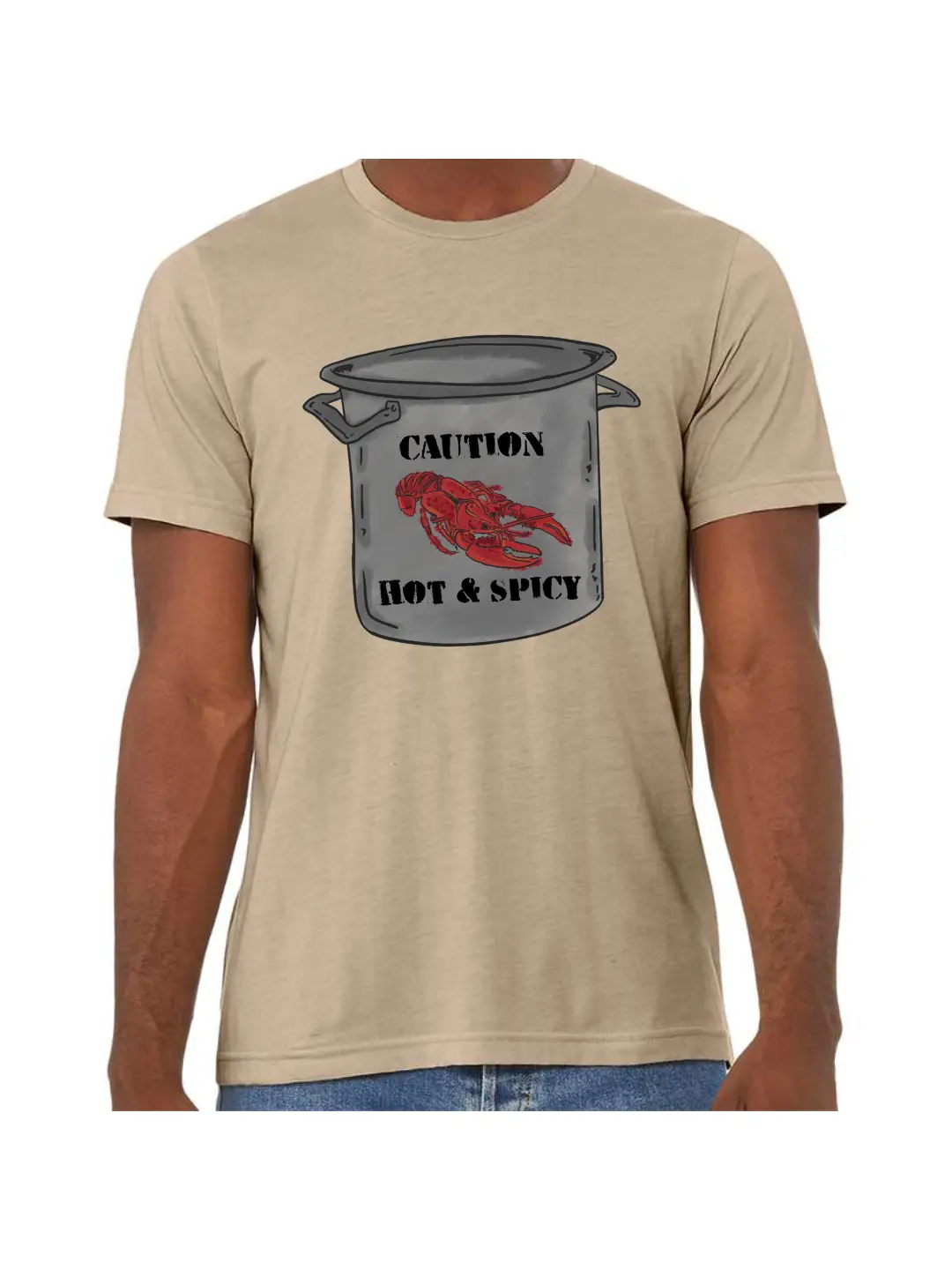 A Heather Tan T shirt with a graphic of a large stainless steel pot, on the pot at the top is the word Caution with a crawfish below and the words Hot & Spicy underneath