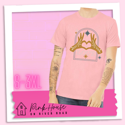 Pink Jersey tee with a graphic. Graphic is of two tattooed hands making a heart in front of an archway with stars and the word Love in the archway.