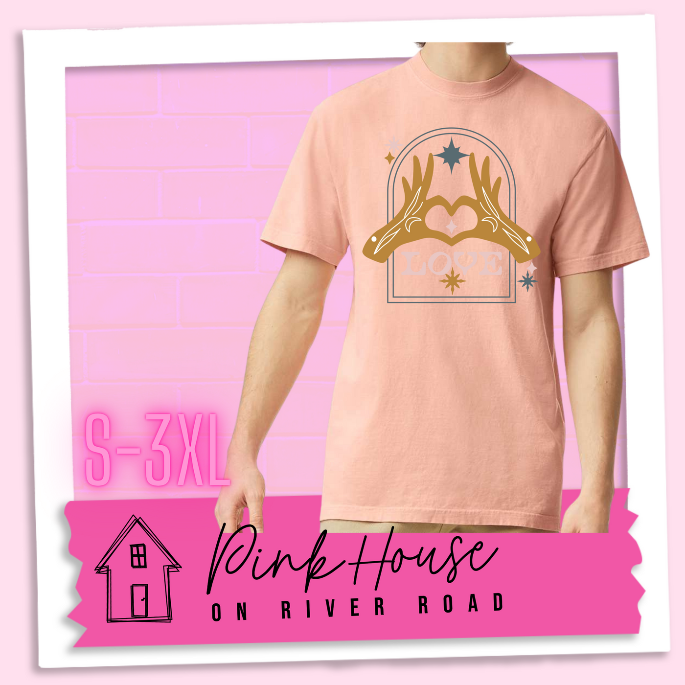 Peach tee with a graphic. Graphic is of two tattooed hands making a heart in front of an archway with stars and the word Love in the archway.
