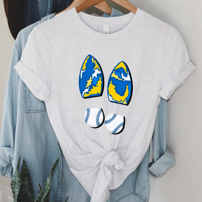 Ash Tee. Graphic is a pair of boot prints, The heel is a baseball print with blue stitching the sole is a abstract Royal, white, and yellow print.