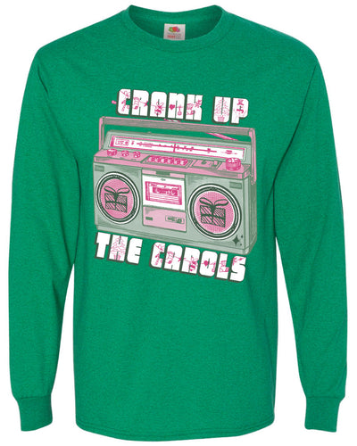 Green long sleeve tee with graphic. Graphic has an old school boom box in the middle, the boom box is green with pink highlights and the speakers have the outline of presents on them. There is text above the boombox that is white with a green shadow and pink Christmas designs that says "Crank up" and below the boom box that says "The Carols"