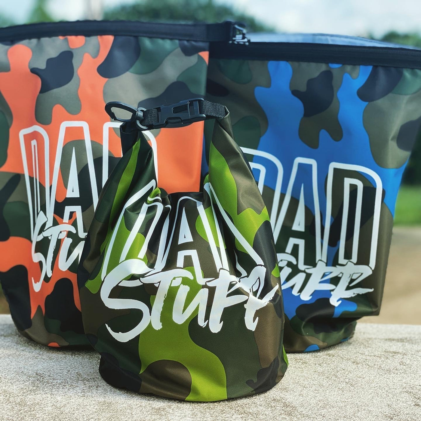 All three colors of camo dry bags with the words Dad Stuff