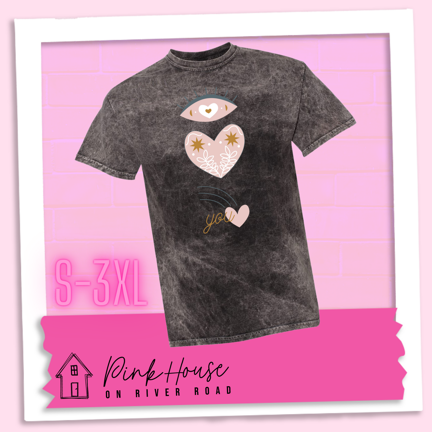 Black Mineral wash tee with a graphic of an eye with a heart for the pupil and underneath that a heart with a floral and star design and a shooting heart with the word you. The graphic represents eye heart you