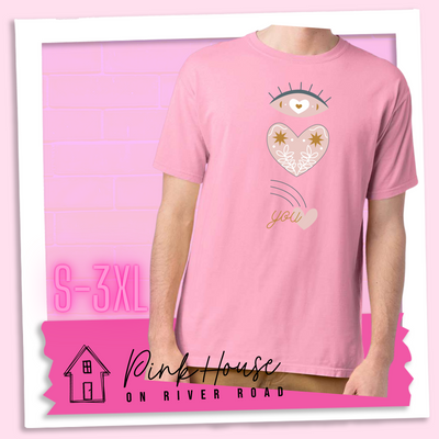 Cotton Candy tee with a graphic of an eye with a heart for the pupil and underneath that a heart with a floral and star design and a shooting heart with the word you. The graphic represents eye heart you