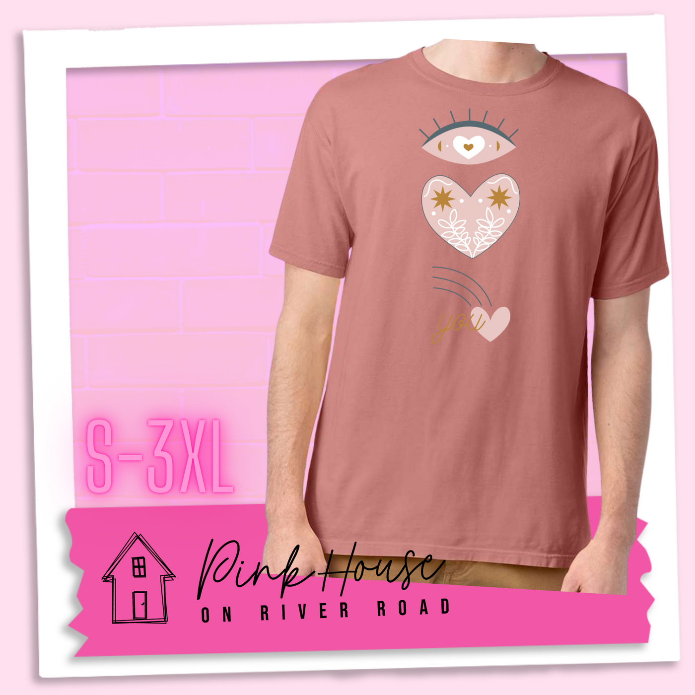 Mauve tee with a graphic of an eye with a heart for the pupil and underneath that a heart with a floral and star design and a shooting heart with the word you. The graphic represents eye heart you