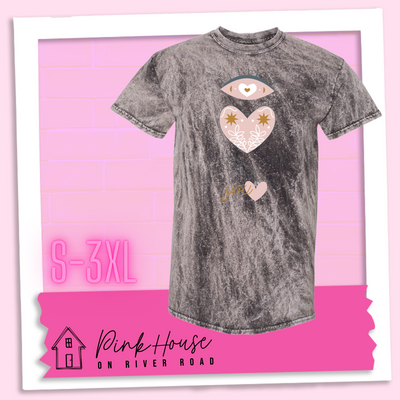 Charcoal Mineral Wash tee with a graphic of an eye with a heart for the pupil and underneath that a heart with a floral and star design and a shooting heart with the word you. The graphic represents eye heart you