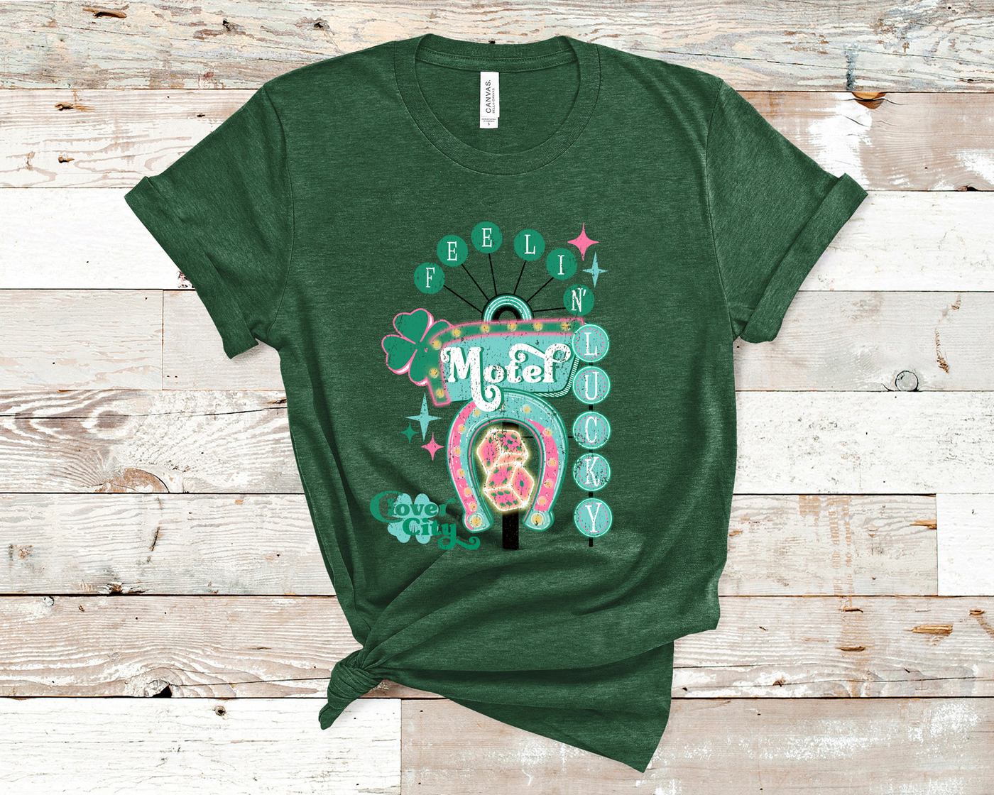 Grass Green Tee. Graphic of a vintage Neon Sign The word feeling with each letter in green circles at the top with the word lucky down the side with each letter in a turquoise circle. There is a sign in the center with the word motel in it, underneath there is a horse shoe with dice inside at he bottom of the sign. There is also a four leaf clover with the word clover city over it in green.
