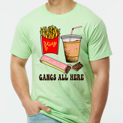 Neon Mint shirt with graphic. Graphic is a container of fries with a yellow cursive font that says fries. A cup of iced coffee with a pink cursive font that says coffee and a chocolate bar witha pink wrapper and a blue cursive font that says chocolate. Under the food there is a black bubble font that says gangs all here.