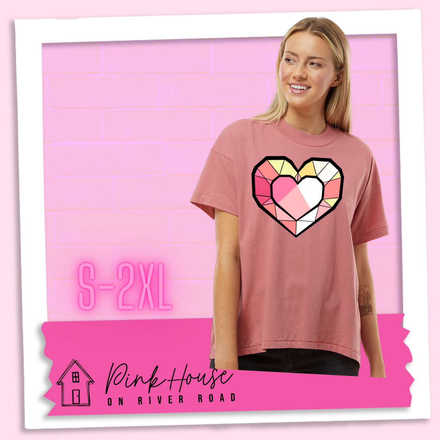A blonde woman wearing a oversized mauve HiLo graphic tee. the graphic is of ageometric heart, it has black outlines to make it look like a gem with different shades of pinks, yellows, and white.