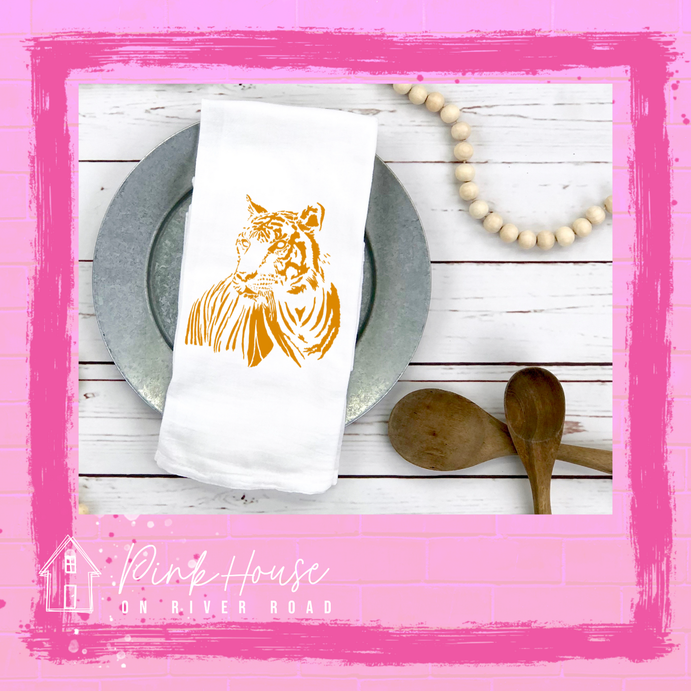 A white dish towel with a gold tiger on it. 