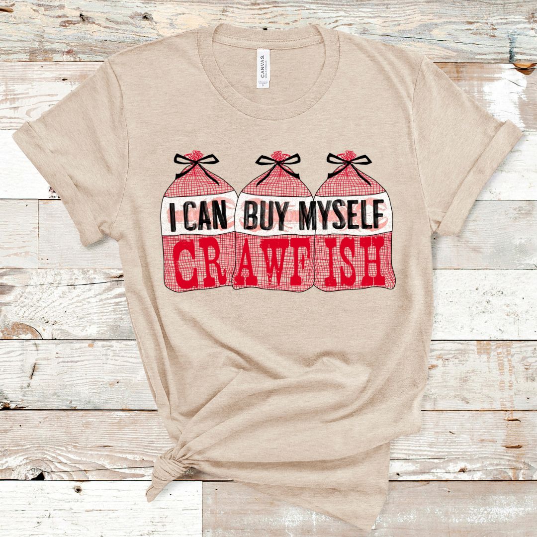Heather Tan Tee. Graphic is 3 bags of crawfish lined up next to each other. The labels read "I Can Buy Myself" and the word "Crawfish" In red on the bags under the labels