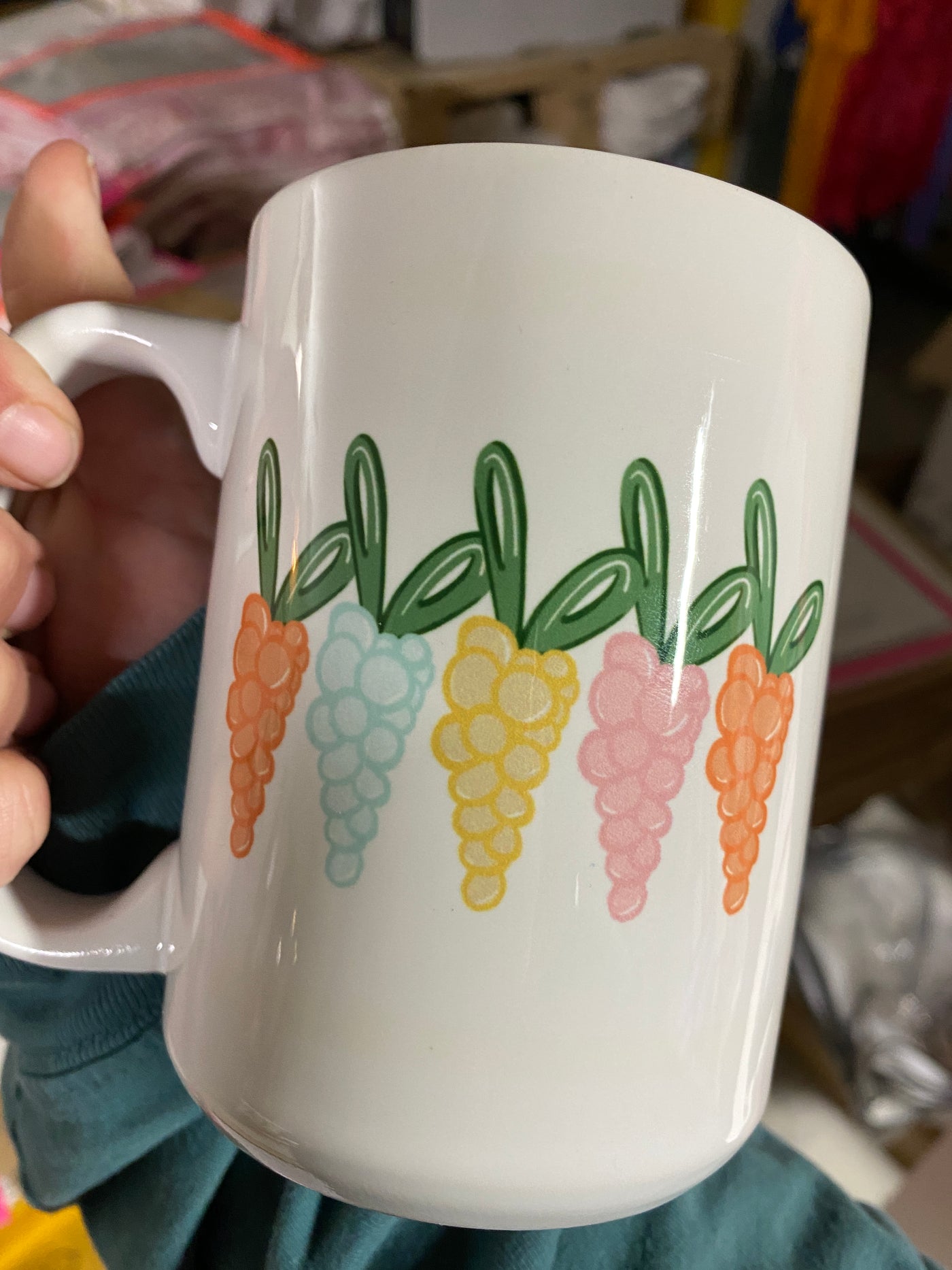 Hand holding a coffee mug. Coffee Mug has carrots made of bubbles in pastel colors