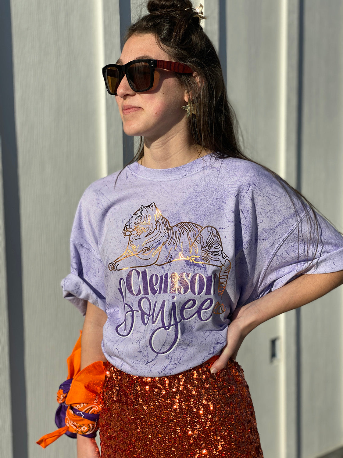 Brunette Model wearing a Purple Tie Dye Shirt with a gold foil tiger and the words Clemson Boujee in purple with a white shadow under the tiger.