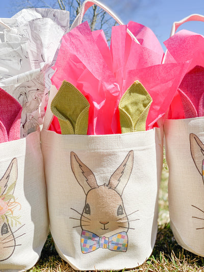 Canvas easter basket with cloth bunny ears and a graphic of a bunny wearing a bowtie with multicolored squares on it.