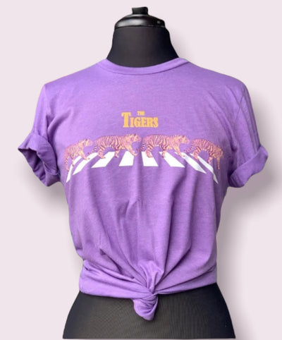 Heather Purple Shirt. Abbey Road cross walk with purple and gold tiger walking across with the words "The Tigers" in gold above.