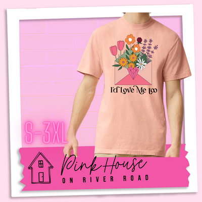 Peach tee with a graphic of a pink envelope filled with different types of flowers and a geometric heart seal. The text underneath reads "I'd Love Me Too"