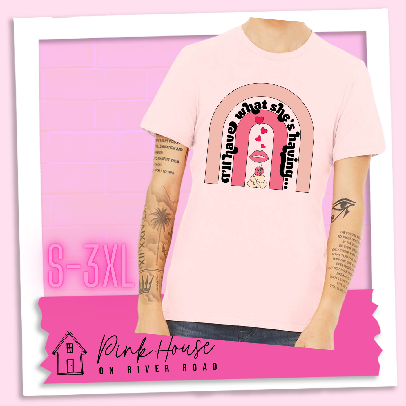 Soft Pink tee with a graphic of a strawberry dessert and a set of lips with hearts, there is a pink arch going over the art. There is a retro font arched over the pink art that says "I'll have what she's having..." in black with another arch above that in light pink.