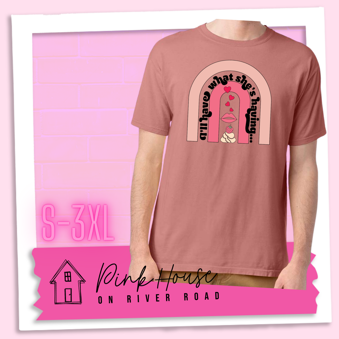 Mauve tee with a graphic of a strawberry dessert and a set of lips with hearts, there is a pink arch going over the art. There is a retro font arched over the pink art that says "I'll have what she's having..." in black with another arch above that in light pink.
