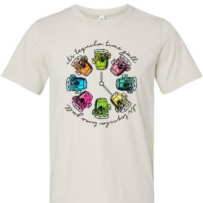 Dust tee with a graphic. Graphic has a clock in the center with multicolored margaritas instead of numbers and around the outside of the clock are the words "It's tequila time y'all" in black cursive font.