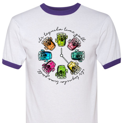 Purple & white ringer tee with a graphic. Graphic has a clock in the center with multicolored margaritas instead of numbers and around the outside of the clock are the words "It's tequila time y'all" in black cursive font.