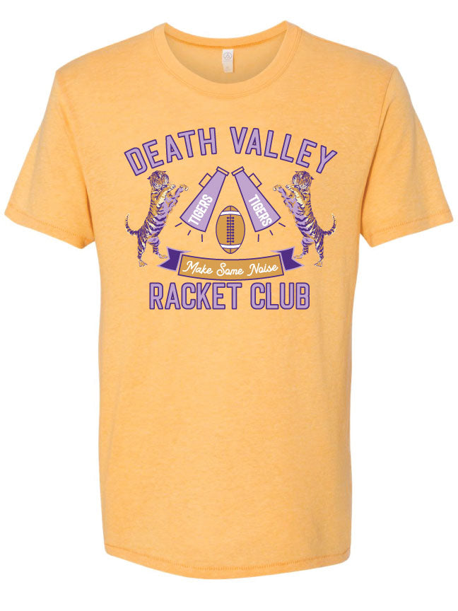 Yellow Tee. Light purple text with a dark purple outline at the top that reads "Death Valley" Underneath there is a football in the middle with two purple megaphones that say tiger in white on each side of the football. There are tigers with purple stripes on either side of the megaphone and under that there is a yellow and purple banner that says " Make Some Noise". At the bottom there is purple text matching the text on top that says " Racket Club" 