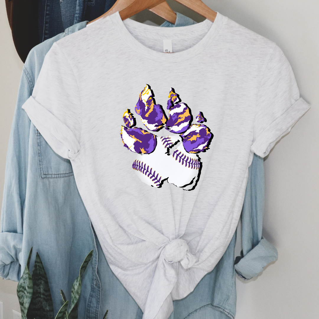 Ash Tee. Graphic of a paw print, the pad of the paw is baseball print with purple laces and the toe pads are abstract purple, yellow, and white print.