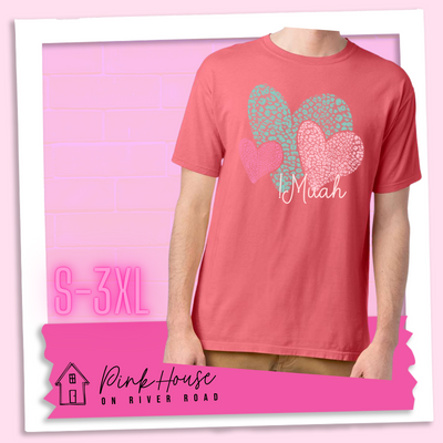 Coral tee with 3 different colored leopard print hearts in various sizes in the lower right hand corner of the graphic is the word Muah in light punk script