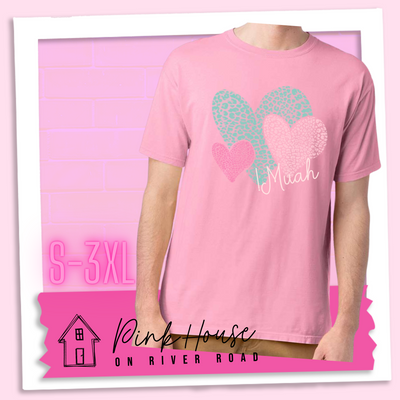 Cotton Candy Pink tee with 3 different colored leopard print hearts in various sizes in the lower right hand corner of the graphic is the word Muah in light punk script