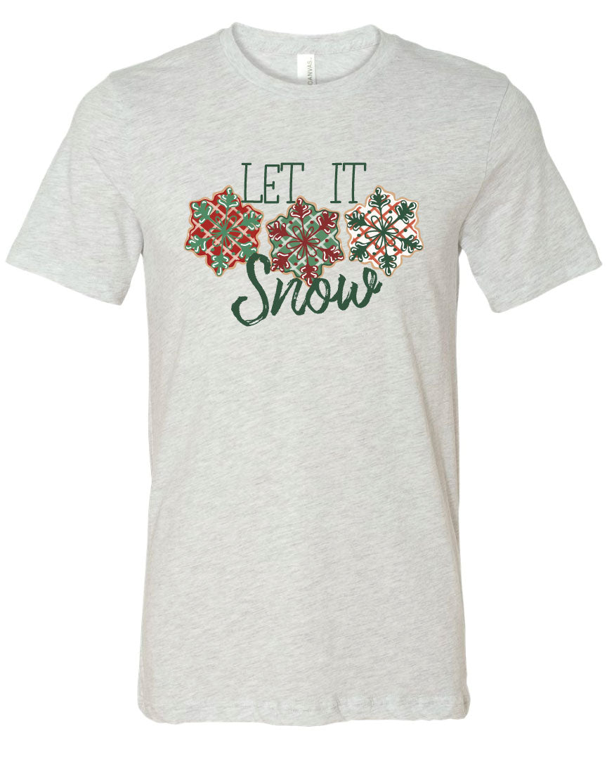 Ash Tee with the words Let It in think block letters at the top with three snowflakes underneath. Far left snowflake is red with beige stripes and a green snowflake design on the top, Middle snowflake is green with white stripes and a dark red snowflake design on the top, and the right snowflake is white with red stripes and a dark green snow flake design on top and the word snow in a brush script underneath.