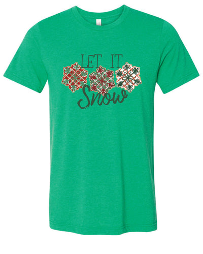 Green tee with the words Let It in think block letters at the top with three snowflakes underneath. Far left snowflake is red with beige stripes and a green snowflake design on the top, Middle snowflake is green with white stripes and a dark red snowflake design on the top, and the right snowflake is white with red stripes and a dark green snow flake design on top and the word snow in a brush script underneath.