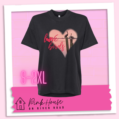 An oversized black HiLo tee with graphic. Graphic is a pink heart with a photo of some pelicans standing on post in the water. To the left of the heart are the words love birds in a pink cursive font and the O in love has been replaced with a heart.