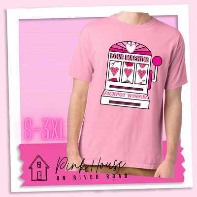 Cotton Candy Pink Tee with a graphic. Graphic is of a white slot machine with pink accents at the top of the slot machine is an arch with different shades of pink and a heart cut out of the middle. Underneath the are are the words Love machine in hot pink with white dots to look like lights. the reels of the slot machines show three geometric hearts. The slot pull has a pink base with a white handle and pink knob on it. Under the reels are the words Jackpot Winner in pink.