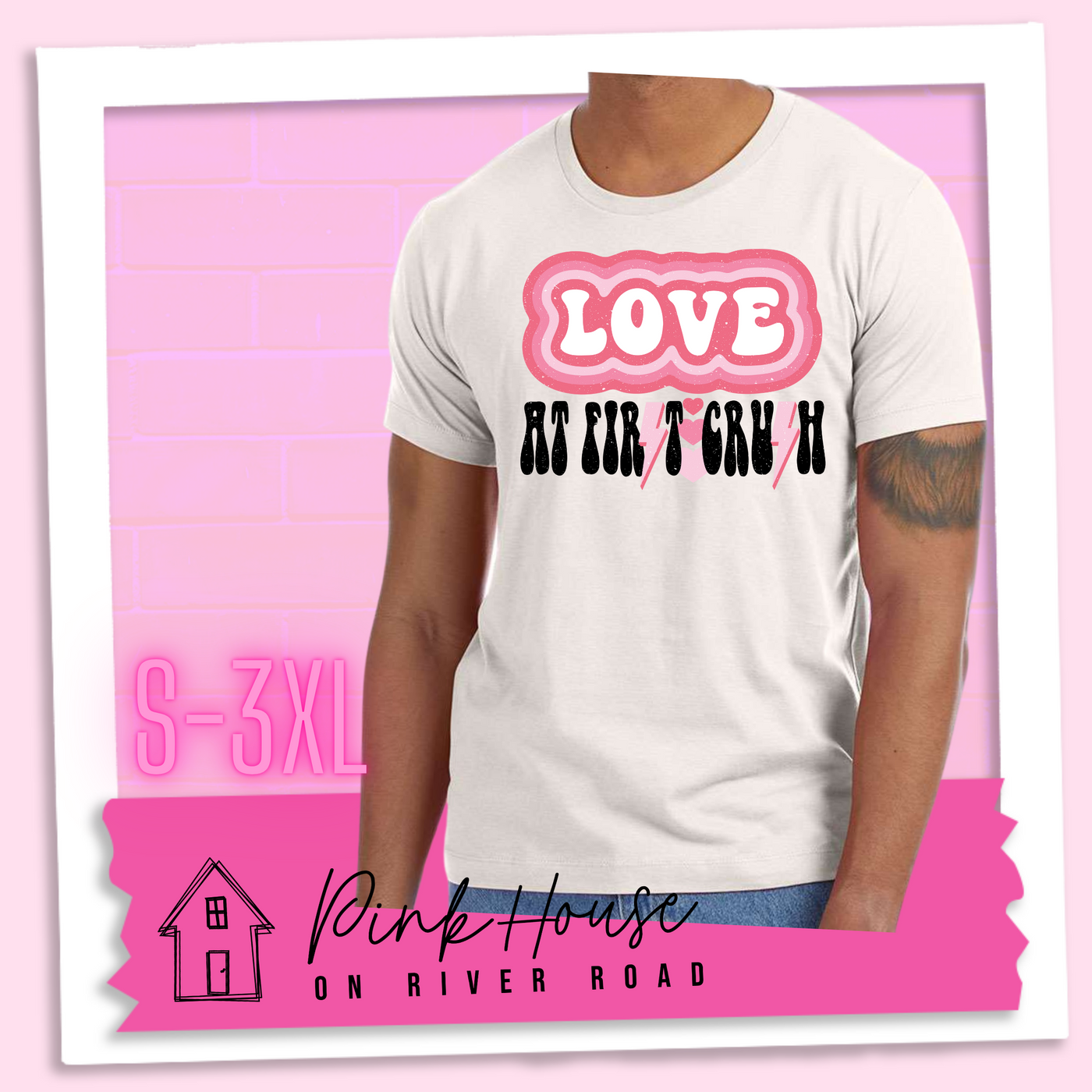 Dust Tee. The graphic has the word Love in retro bubble letters with differetn colored pink outlines radiating from the word, underneath are the worxs at first in black with the s in first replaced with a pink lightning bolt, then there are three different colored hearts followed by the word crush in the same black font with the S replaced with the same pink lightening bolt.