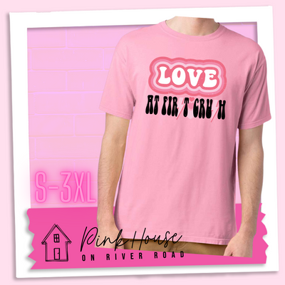 Cotton Candy Pink Tee. The graphic has the word Love in retro bubble letters with differetn colored pink outlines radiating from the word, underneath are the worxs at first in black with the s in first replaced with a pink lightning bolt, then there are three different colored hearts followed by the word crush in the same black font with the S replaced with the same pink lightening bolt.