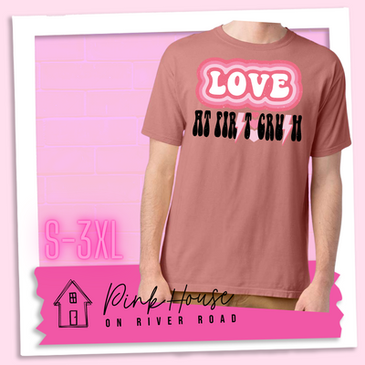 Mauve Tee. The graphic has the word Love in retro bubble letters with differetn colored pink outlines radiating from the word, underneath are the worxs at first in black with the s in first replaced with a pink lightning bolt, then there are three different colored hearts followed by the word crush in the same black font with the S replaced with the same pink lightening bolt.