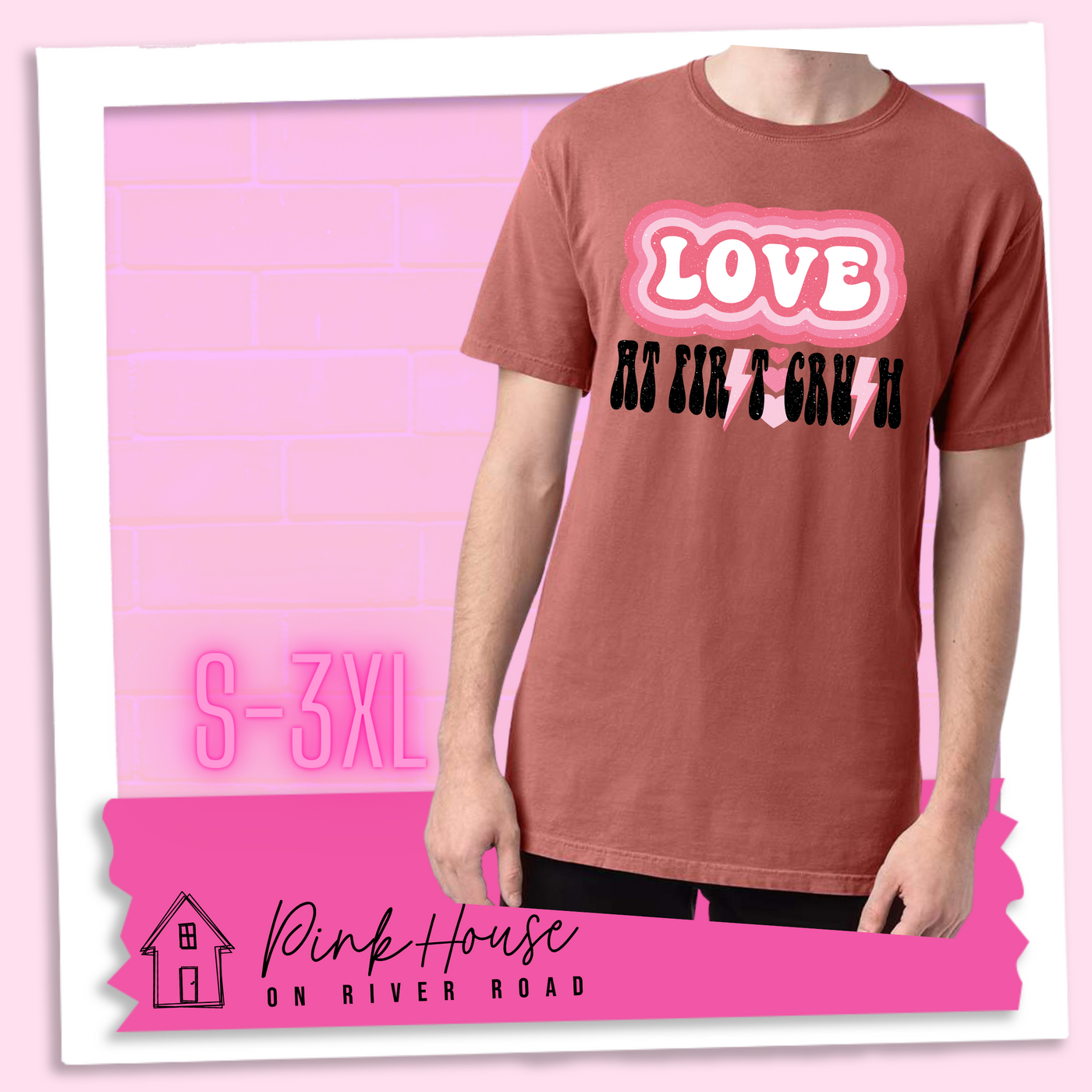 Nantucket Red Tee. The graphic has the word Love in retro bubble letters with differetn colored pink outlines radiating from the word, underneath are the worxs at first in black with the s in first replaced with a pink lightning bolt, then there are three different colored hearts followed by the word crush in the same black font with the S replaced with the same pink lightening bolt.
