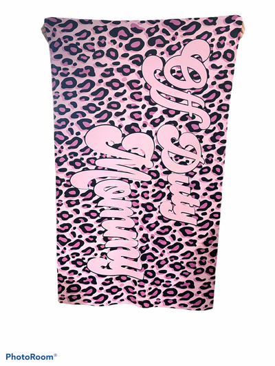 A pink leopard print beach towel with pink cursive font that says off duty mommy