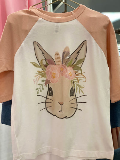 A white raglan tee with peach sleeves and a graphic of a bunny wearing a floral crown