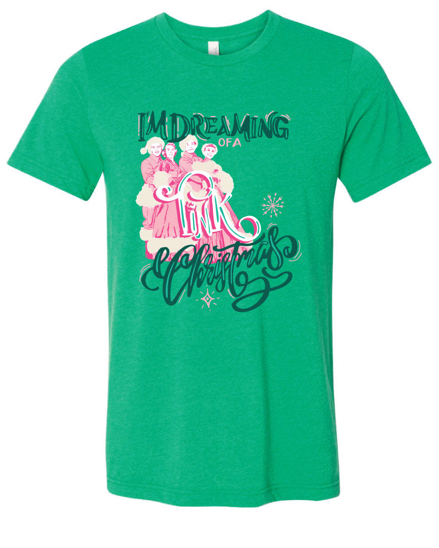 Green tee with the words Im Dreaming in a green whimsical font underneath there is the wors of a in a pink color there is a graphic of two couples in vintage winter clothing and the word Pink over the couple and the word Christmas at the bottom in the same green font as the words im dreaming