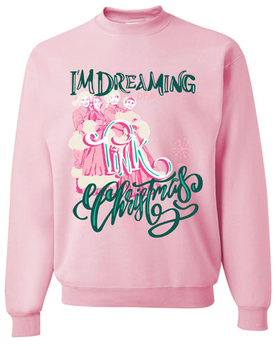 Pink sweatshirt with the words Im Dreaming in a green whimsical font underneath there is the wors of a in a pink color there is a graphic of two couples in vintage winter clothing and the word Pink over the couple and the word Christmas at the bottom in the same green font as the words im dreaming