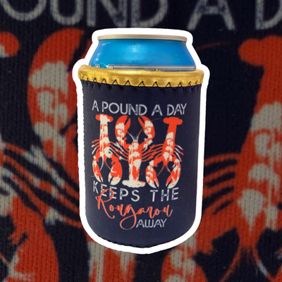 Navy Blue Neoprene Koozie with gold trim. There are three red with white splatter crawfish in alternating directions. The text reads a pound a day keeps the rougarux away. Rougaroux is in red cursive all other text is in white.