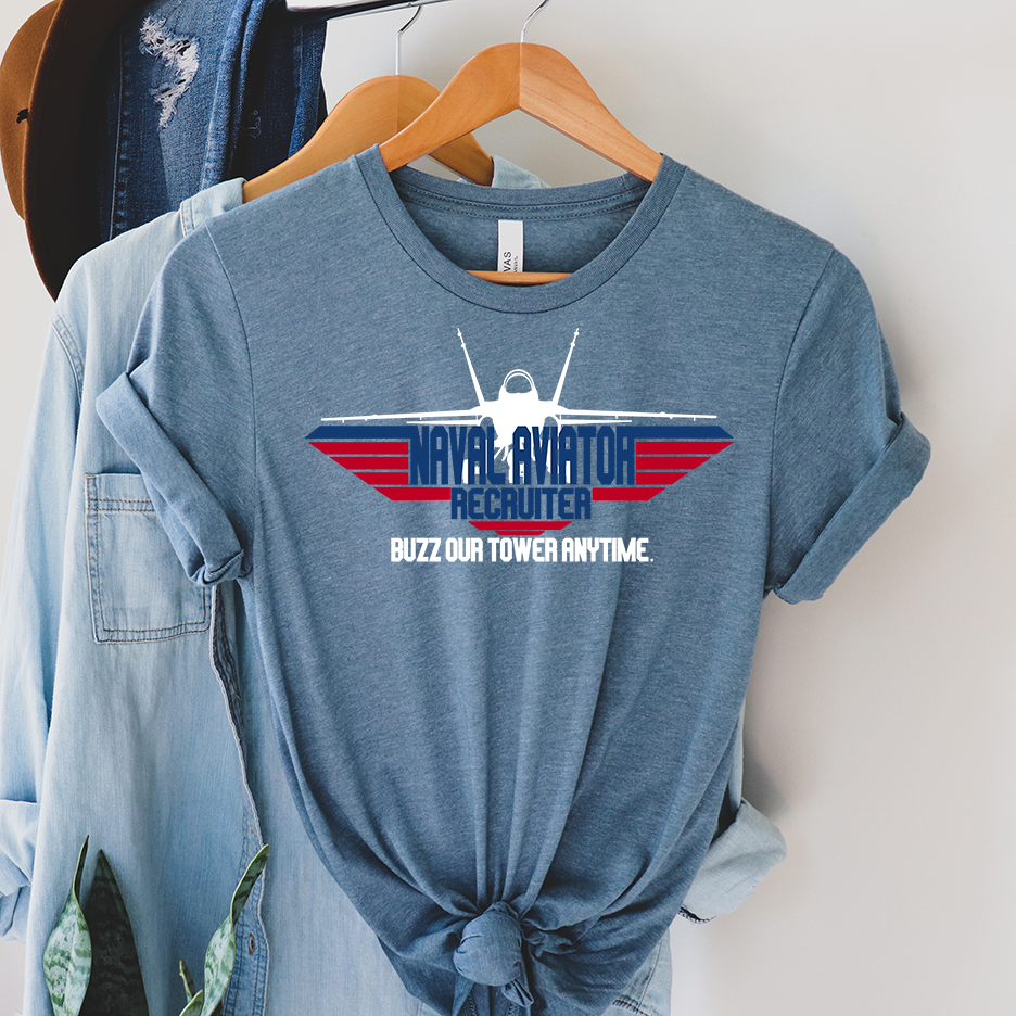 Slate Blue Tee with a Fighter jet in white and the words Naval Aviator Recruiter in blue with red bars and the words buzz our tower anytime in white underneath the words 